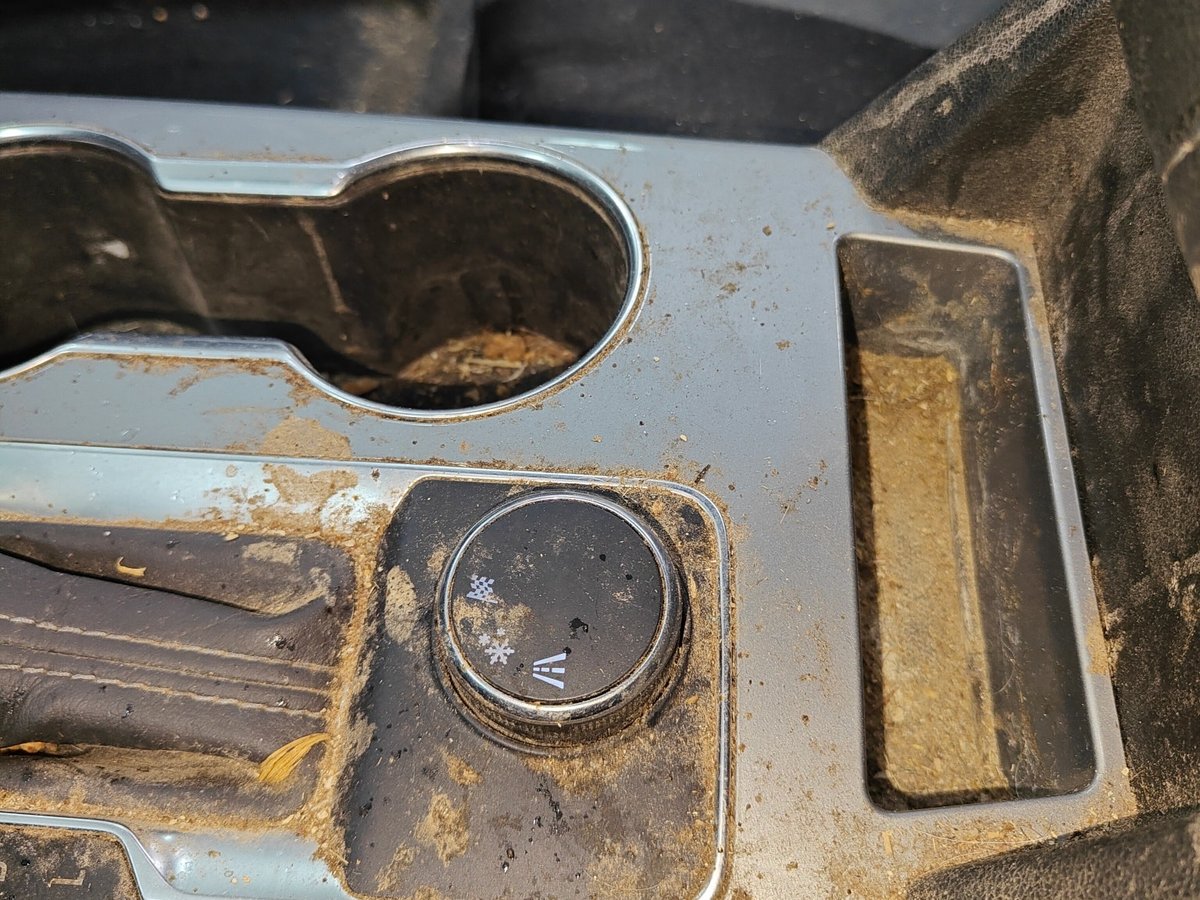Center console covered in dried mud and grime before detailing