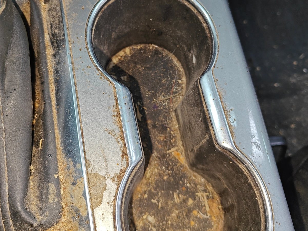 Cup holders packed with sludge and debris before cleaning